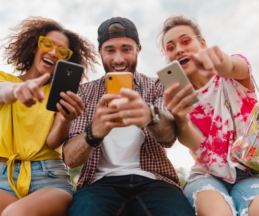 Grupo de pessoas sorrindo olhando o celular